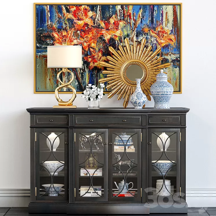 A chest of drawers with a collection of decor a lamp and a set of sculptures
